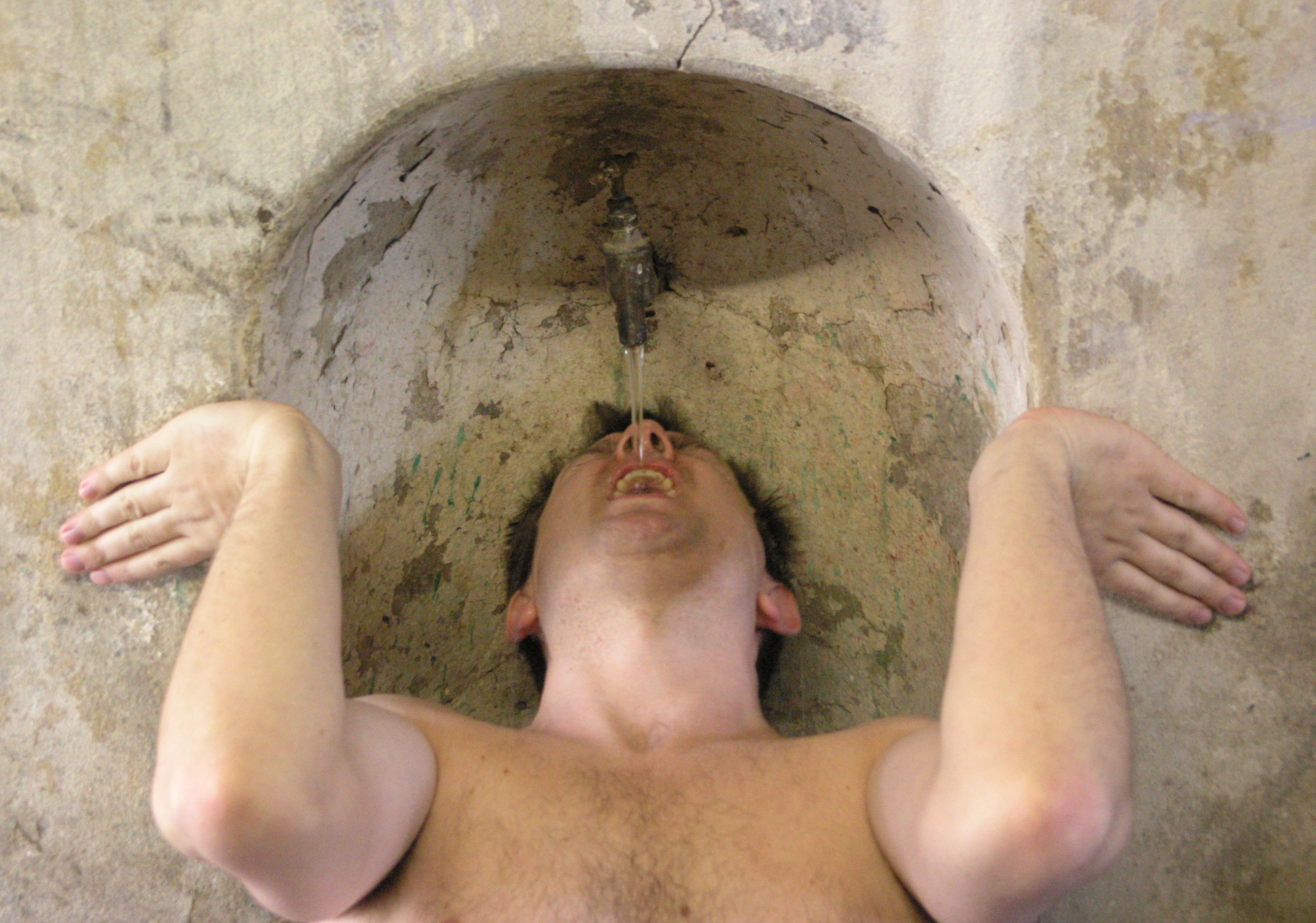 William Pollard lying beneath a stone water spout